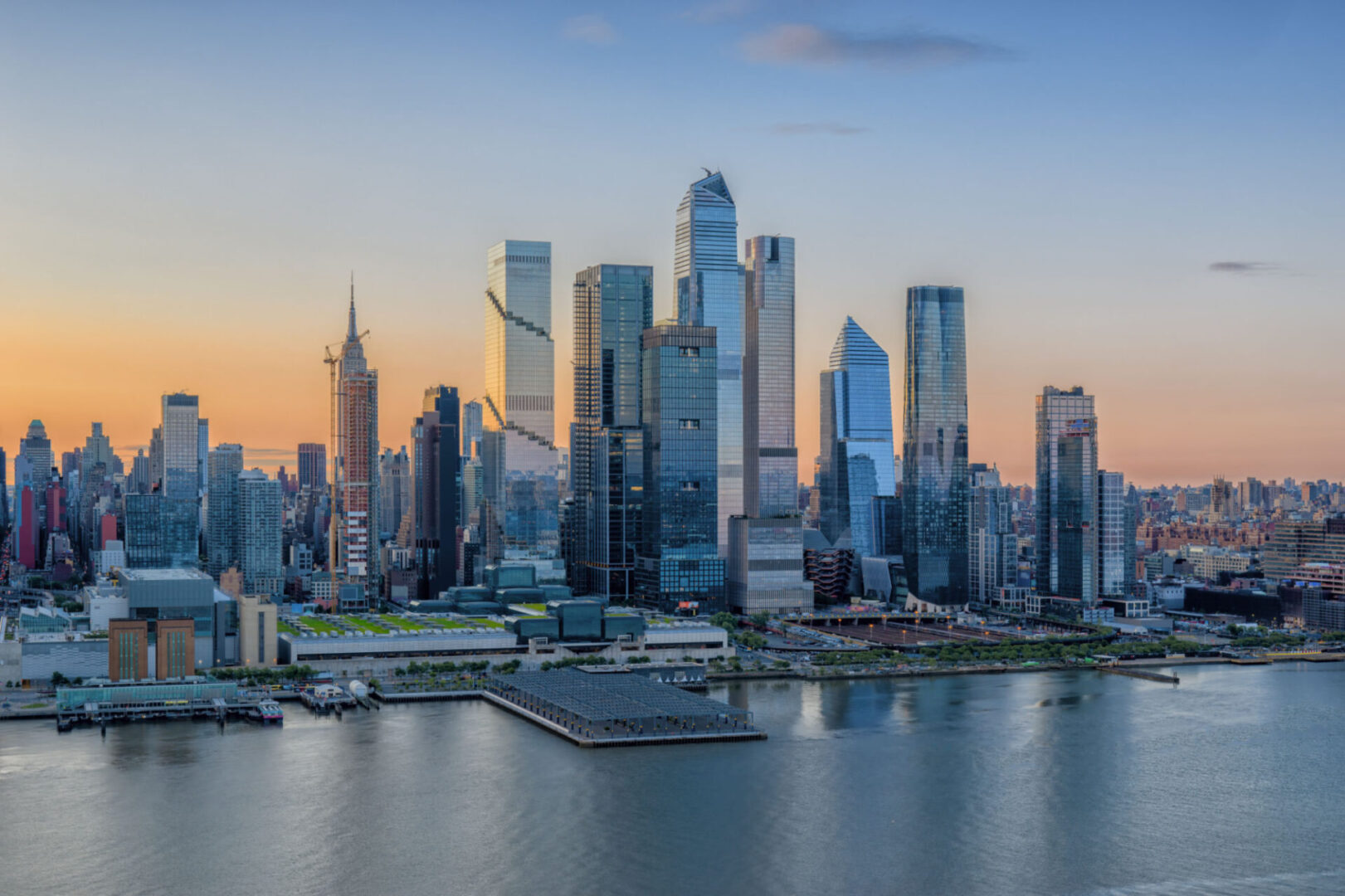 Urban skyline reflecting in river at dusk