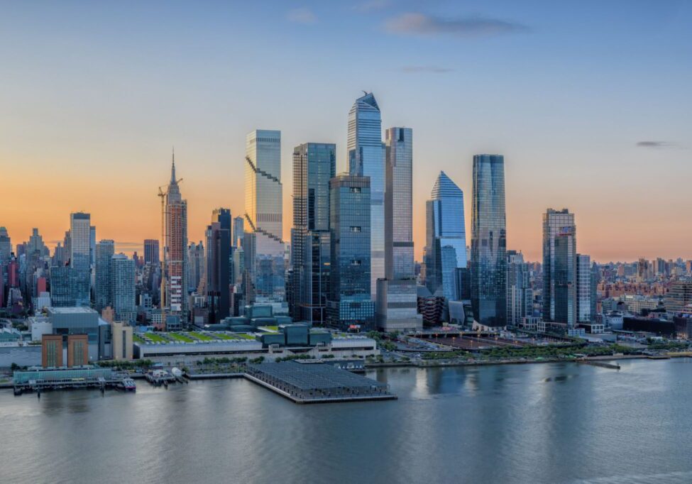 Urban skyline reflecting in river at dusk